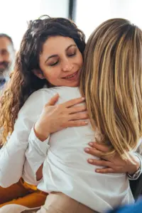 Two Women Hugging In Recovery Center